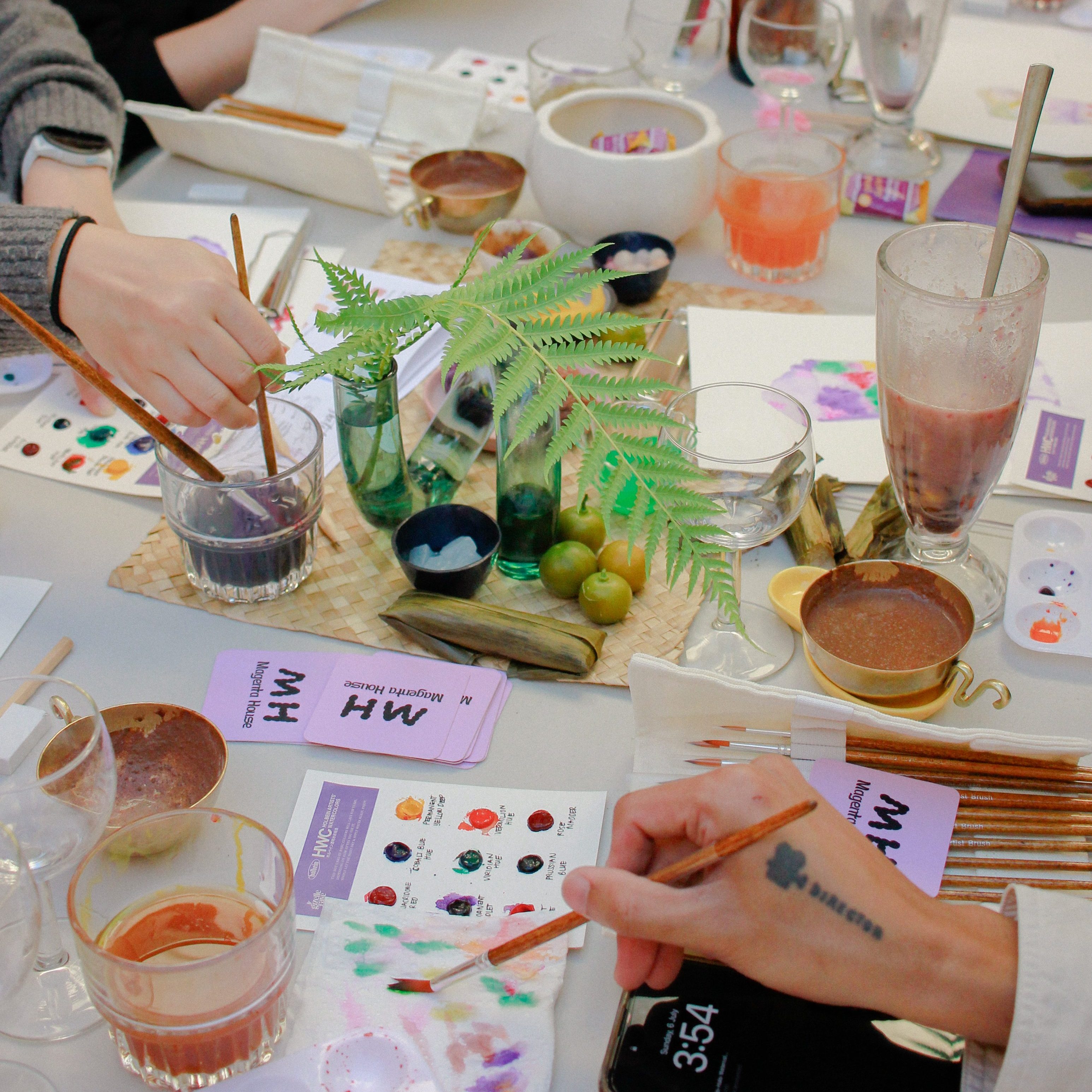 A table filled watercolour materials used by workshop participants, as they paint the traditional Filipino dessert called the Halo-Halo